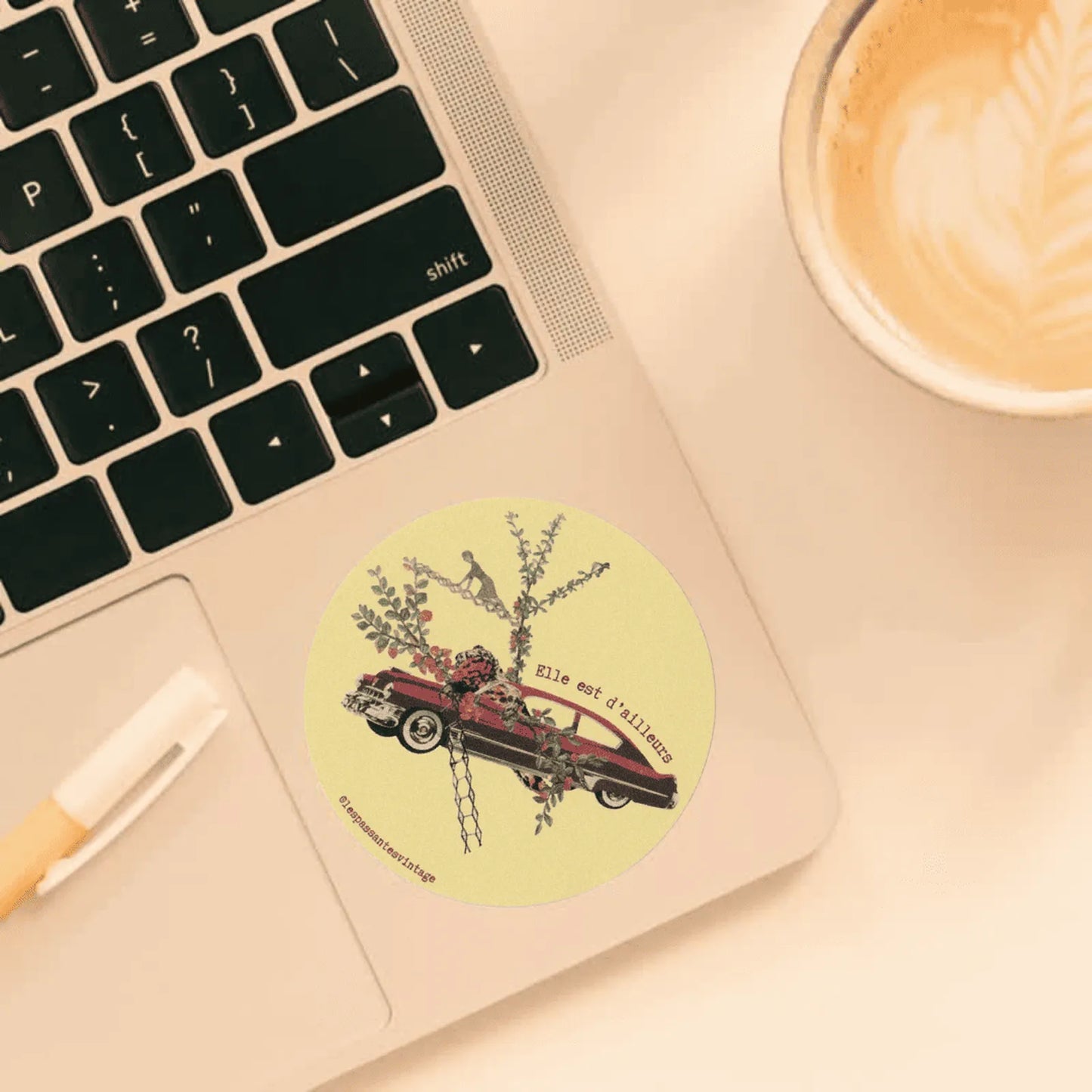 Autocollant rond collage voiture rouge avec fleurs et personnage miniature sur fond vert clair collé sur ordi