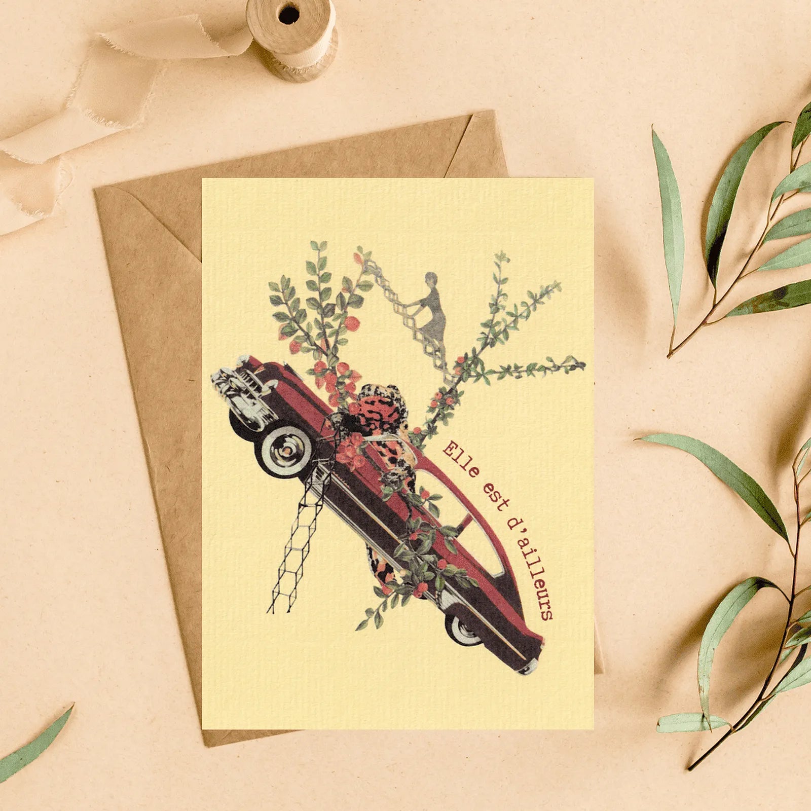 Carte postale vintage « Elle est d’ailleurs » avec illustration collage rétro voiture rouge et fleurs, idée cadeau originale.
