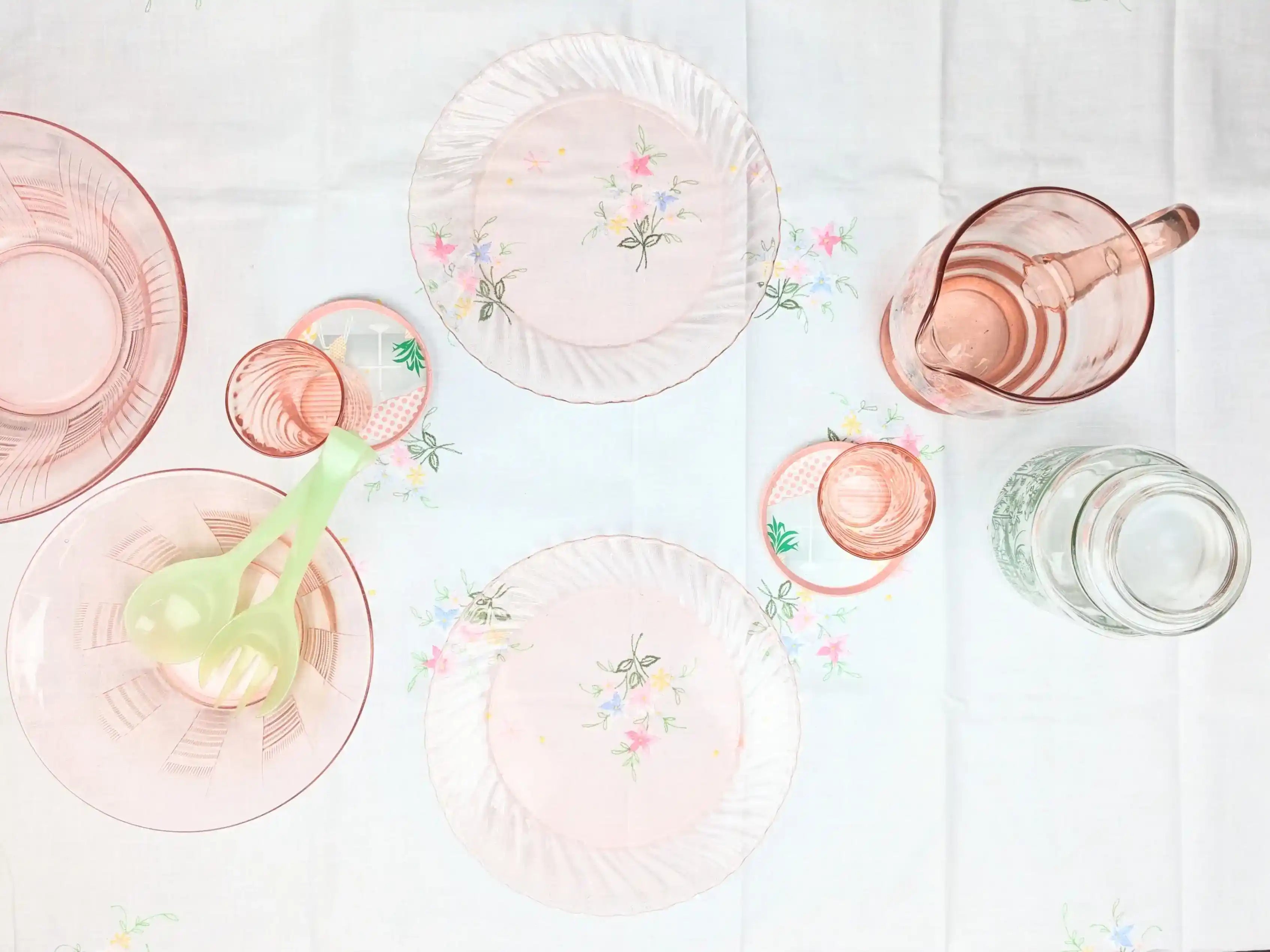 Photo table avec une nappe à fleurs des assiettes, verres, cruches, plats en verre rose arcopal. Table Vintage. les passantes Vitnage