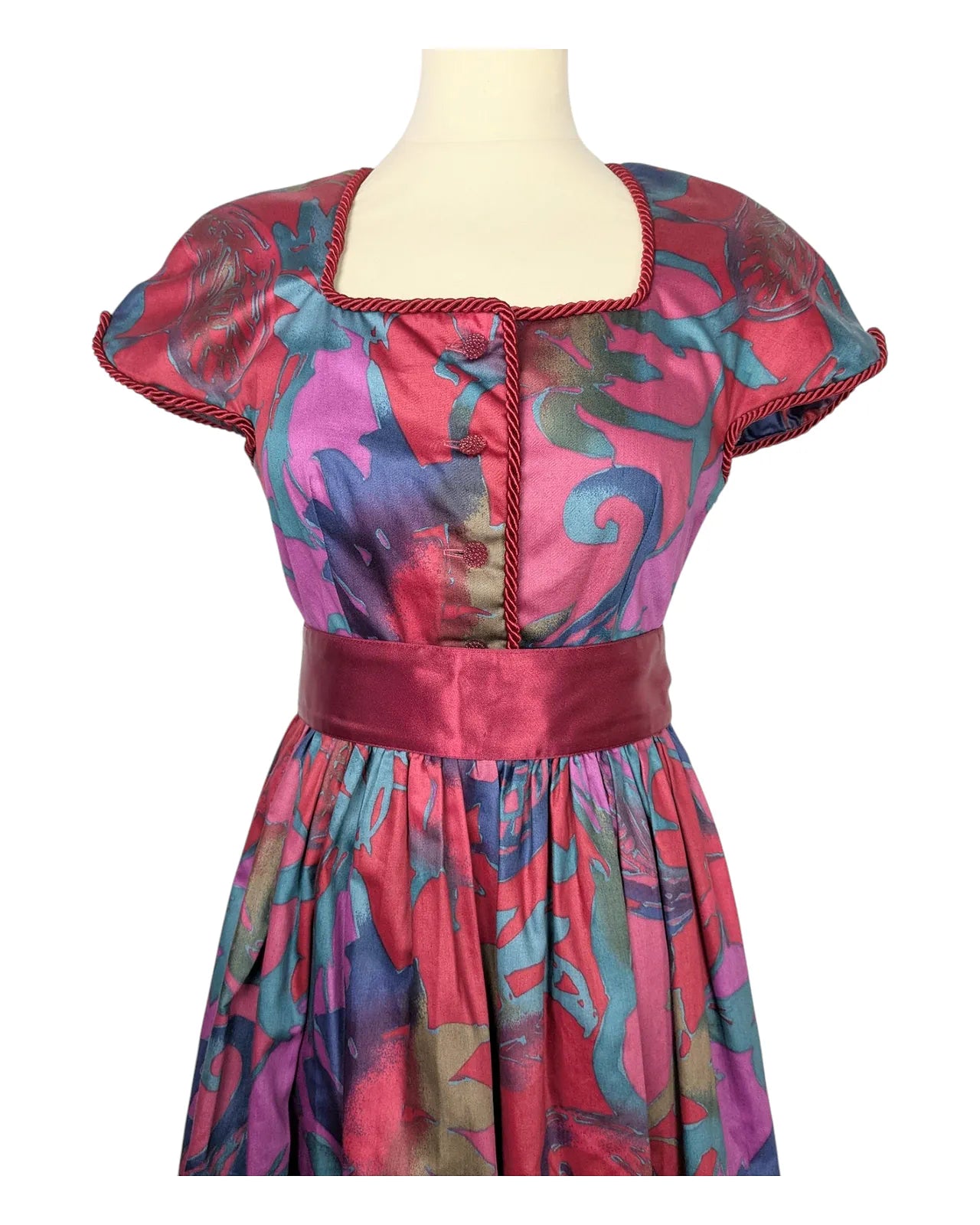 Robe vintage années 80 multicolore à taille cintrée avec ceinture satinée rose et manches courtes