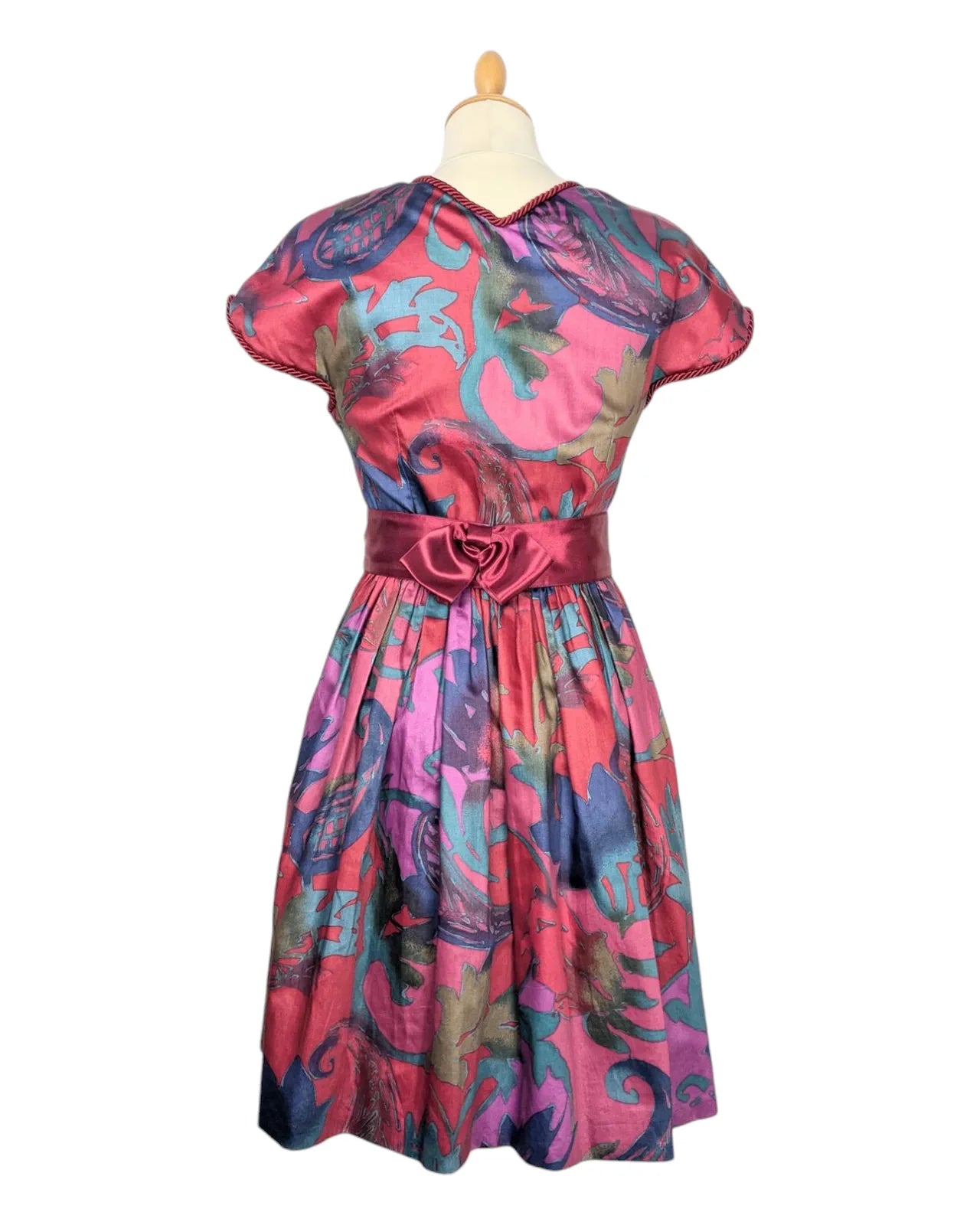 Robe vintage années 80 multicolore à taille cintrée avec ceinture satinée rose et manches courtes
