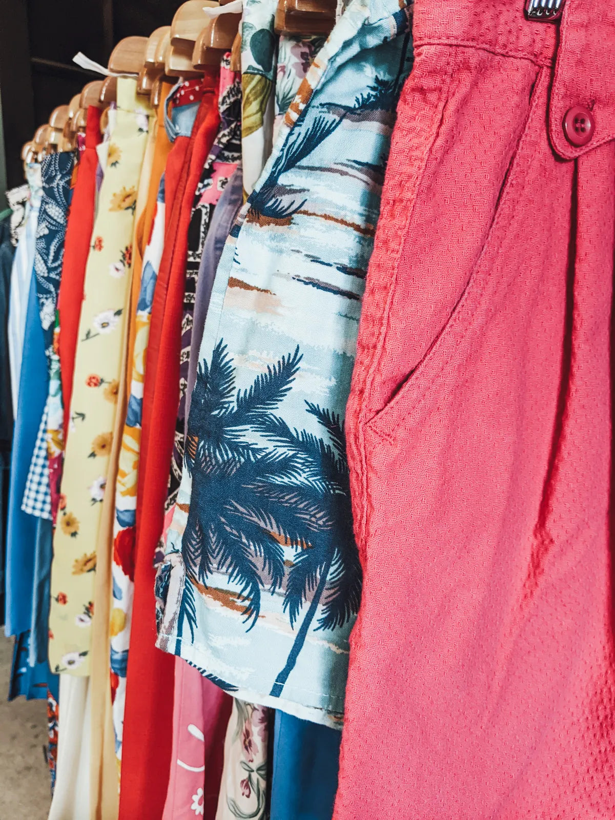 Sélection de vêtements vintage colorés sur cintres en boutique